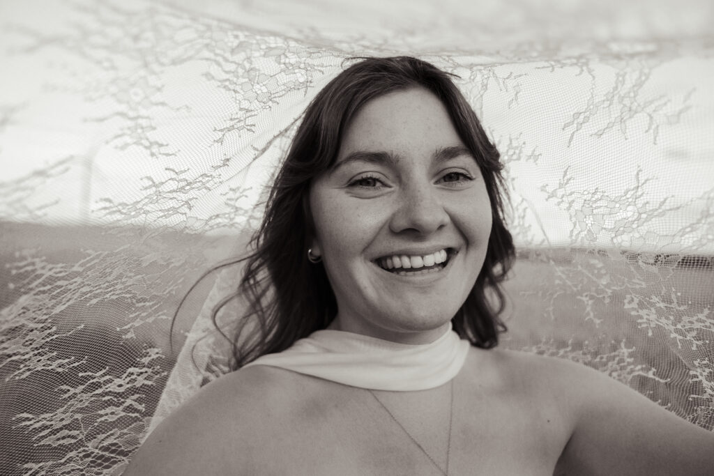 Une jolie mariée souriante sous son voile le jour de son mariage