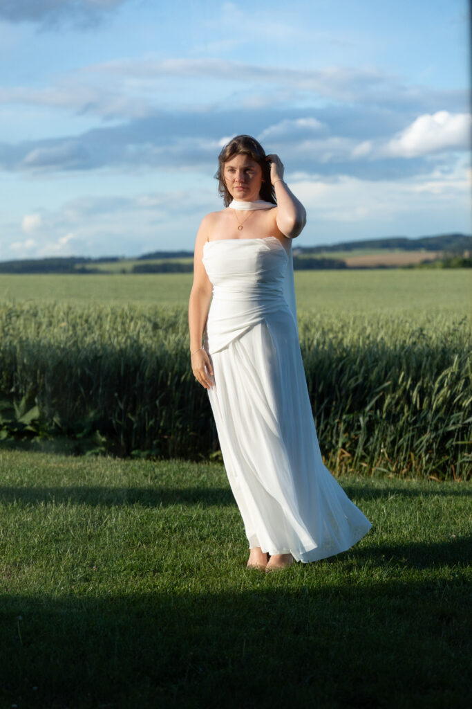 Une mariée posée face à une vitre, on aperçoit sa silhouette, au domaine de mariage Chateau Delacourt